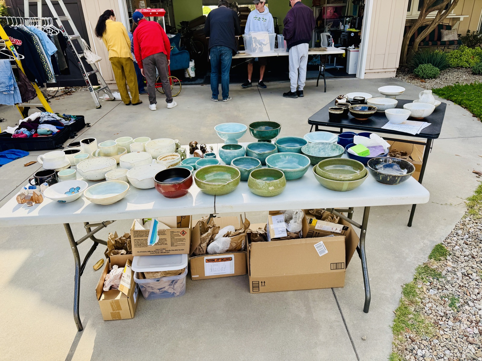 Rows of bowls in green, white and deep brown glazes